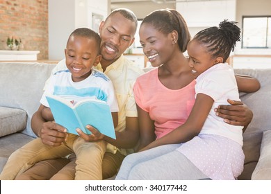 Happy Family Reading A Book Together In Living Room