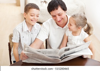 Happy Family Reading A Newspaper. Father With Daughter And Son