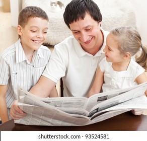 Happy Family Reading A Newspaper. Father With Daughter And Son