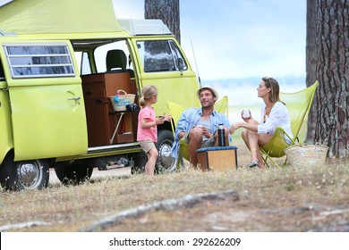 Happy Family Relaxing By Camper Van In Summer