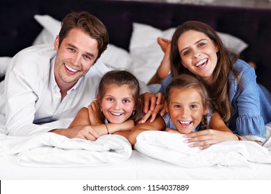 Happy family relaxing in hotel room - Shutterstock ID 1154037889