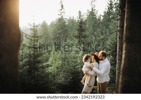 Happy family relaxing in pine forest 