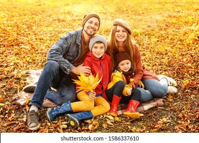 Happy Family Resting In Autumn Park