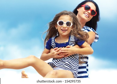 Happy Family Resting At Beach In Summer