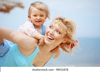 Happy Family Resting At Beach In Summer