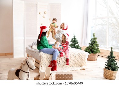 Happy Family Resting In Bedroom On Christmas Eve