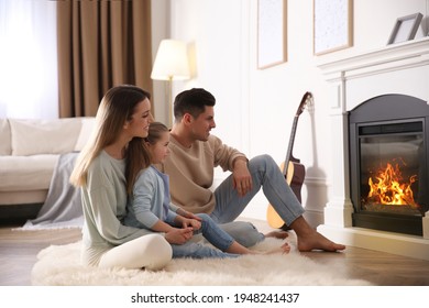 Happy Family Resting Near Fireplace At Home