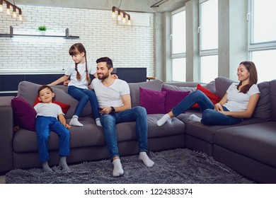 Happy family resting in the room sitting on the sofa. - Shutterstock ID 1224383374