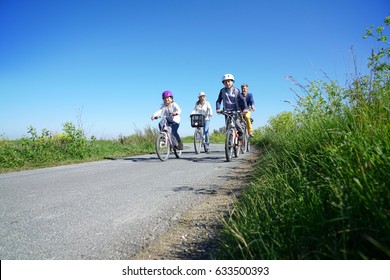 Happy Family Riding Bikes On Week-end In Countryside