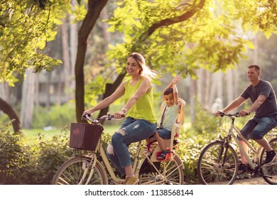 Happy family is riding bikes outdoors and smiling- little boy on bike with mother and father
 - Powered by Shutterstock