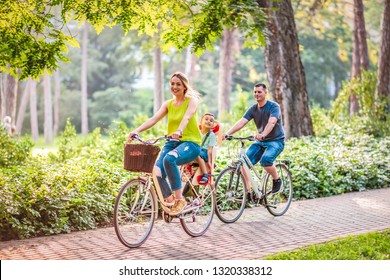 Happy family is riding bikes outdoors and smiling