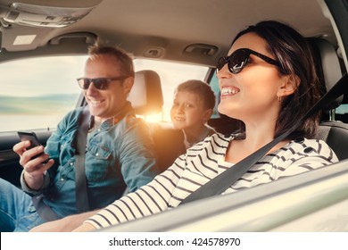 Happy family riding in a car - Shutterstock ID 424578970