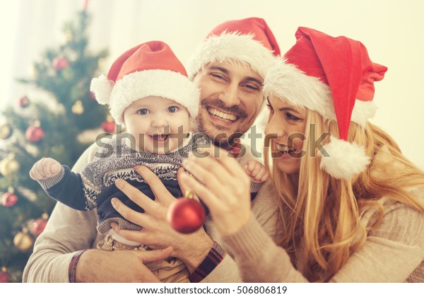 Happy family in the room with the Christmas tree.The family is enjoying ...