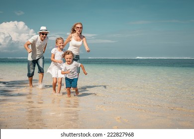 Happy Family Running On The Beach At The Day Time