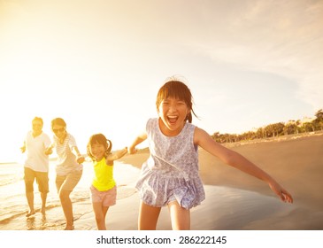 Happy Family Running On The Beach