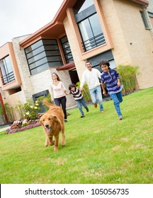 Happy Family Running Outdoors With A Dog