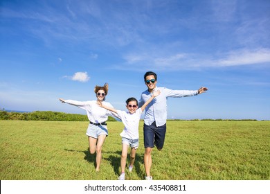 Happy Family  Running Together On The Grass