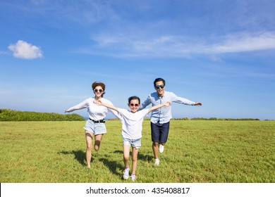 Happy Family  Running Together On The Grass