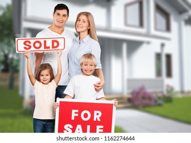 Happy Family With For Sale Sign