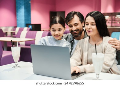 A happy family, seated at a table, engrossed in using a laptop together in a cozy cafe during the weekend. - Powered by Shutterstock