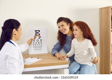 Happy Family See Doctor For Contact Lenses Or Eyeglasses Prescription. Cheerful Positive Mom And Child Having Appointment At Ophthalmologist's Office. Healthcare Professional Uses Eye Chart For Exam