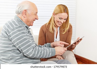 Happy Family With Senior Citizen Using A Tablet Computer