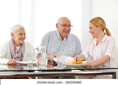 Happy Family With Senior Couple Eating Lunch At Table