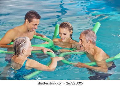 Happy family with senior couple in water of swimming pool