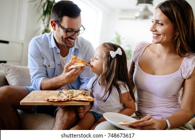 Happy Family Sharing Pizza Together At Home