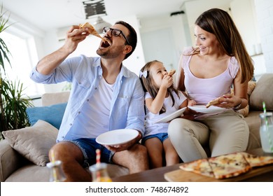 Happy family sharing pizza together at home - Powered by Shutterstock