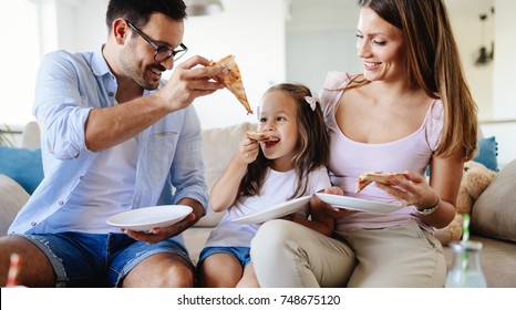 Happy Family Sharing Pizza Together At Home