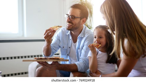 Happy Family Sharing Pizza Together At Home