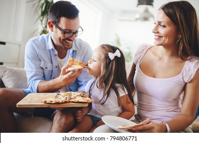 Happy Family Sharing Pizza Together At Home