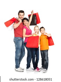 Happy Family With Shopping Bags Standing At Studio Over White Background