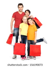 Happy Family With Shopping Bags Standing At Studio Over White Background