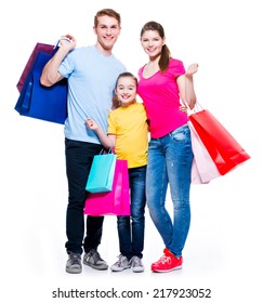 Happy Family With Shopping Bags Standing At Studio Over White Background.