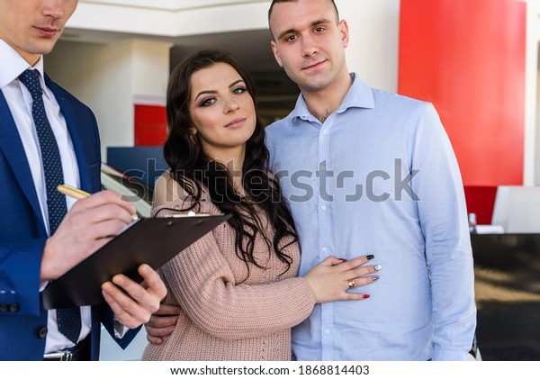Happy family\
signing contract with dealer in\
salon