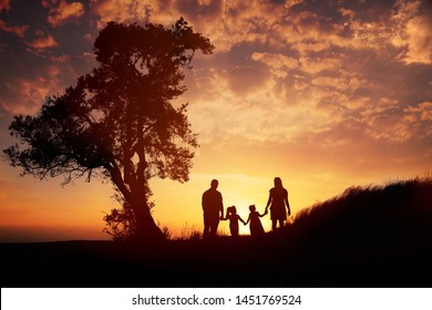 Happy Family Silhouette Standing On Against Sunset Time