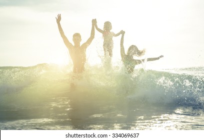 Happy family silhouette in the water. Jumping between the waves