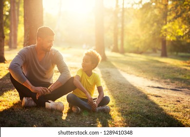 Happy family siting on grass in the park enjoying sunset. Father and daughter together. - Powered by Shutterstock