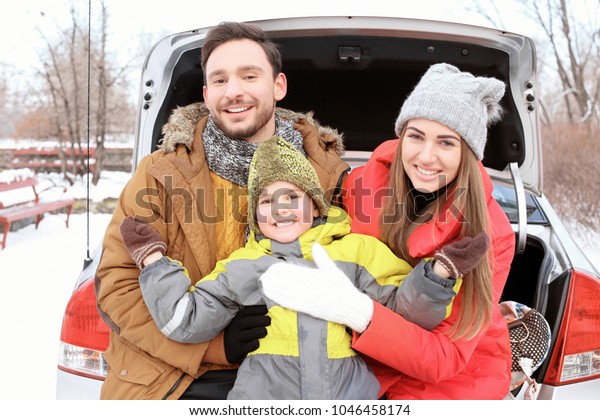 Happy\
family sitting in car trunk on winter\
vacation