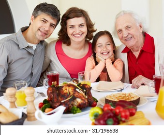 Happy family sitting at celebration table on Thanksgiving Day