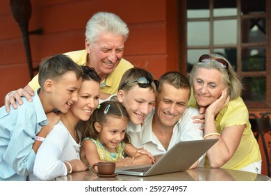 Happy Family Sitting With Laptop On Table