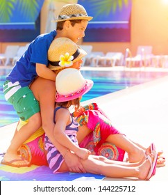 Happy Family Sitting Near Poolside, Mother With Two Cute Kids Enjoying Summer Holidays, Little Sister And Brother With Young Mom On Luxury Resort, Love Concept