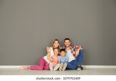 Happy Family Sitting On Floor In New Empty Flat