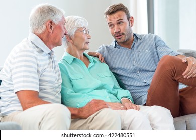 Happy family sitting on sofa in their living room - Shutterstock ID 422480551