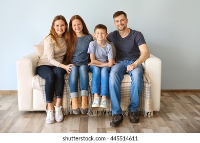 Happy Family Sitting On Sofa