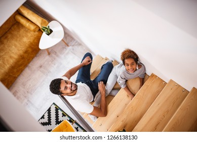 Happy Family Sitting On The Stairs At Home. Top View.