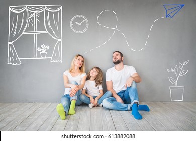 Happy family sitting wooden floor  Father  mother   child having fun together  Moving house day  new home   design interior concept