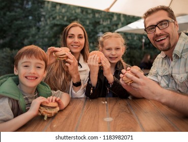 Happy Family Sitting At A Table In A Fast Food Restaurant